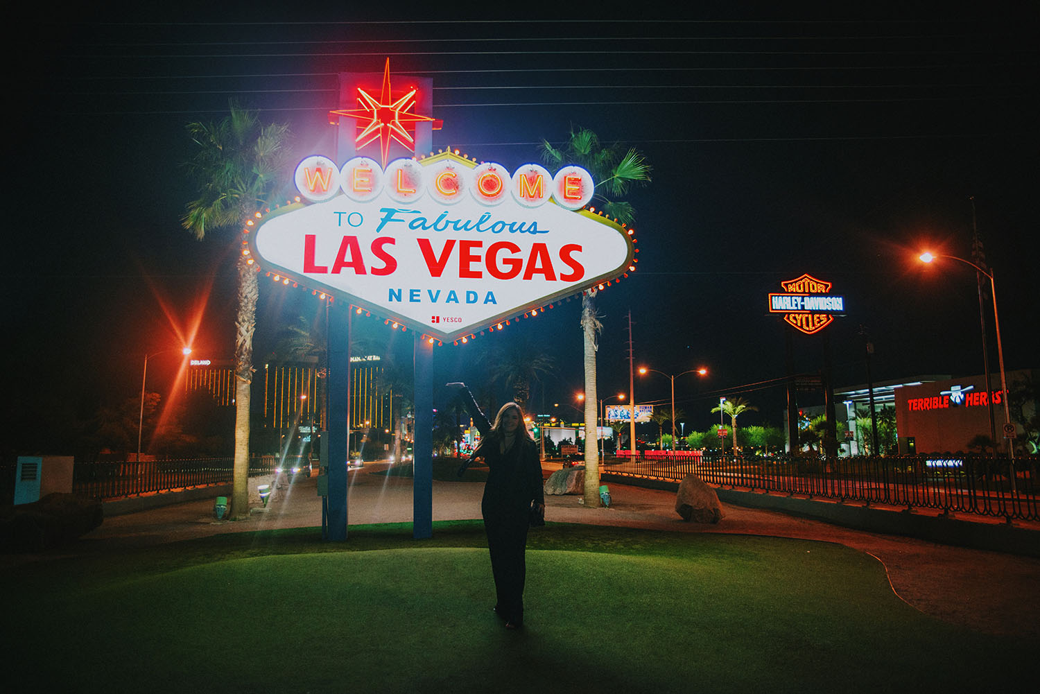 Woman standing in front of Welcome to Fabulous Las Vegas Sign at night