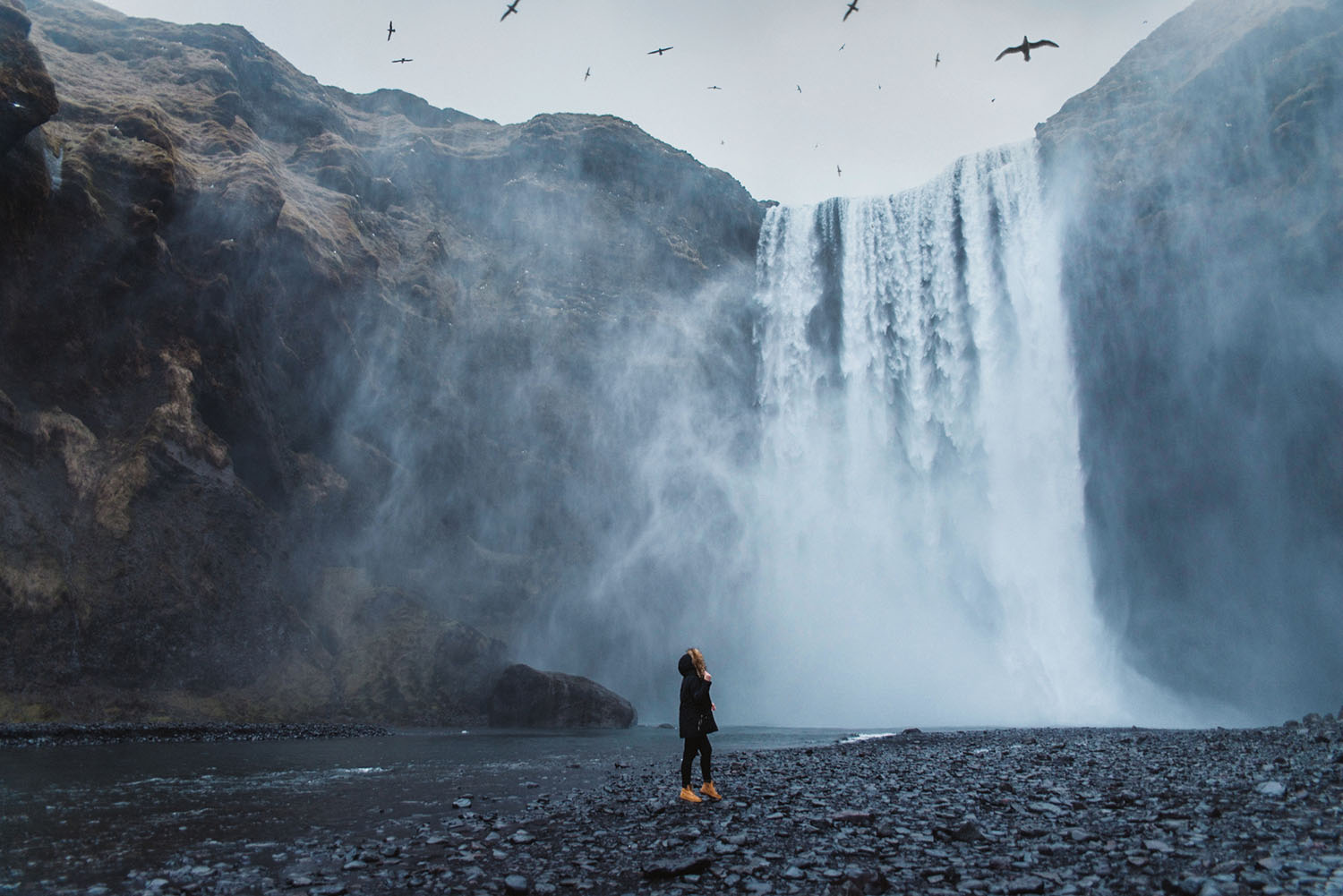 Girl standing in front of Skógafoss Waterfall in Iceland