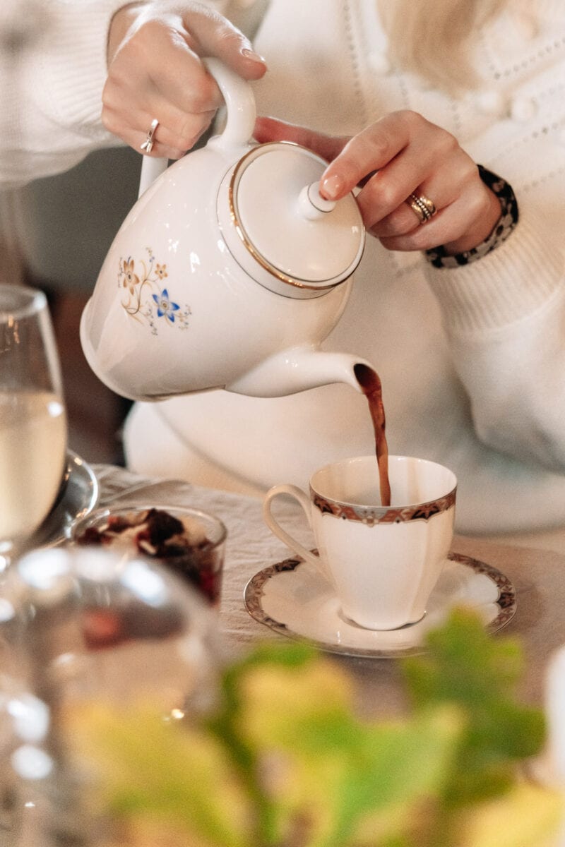 Woman pours a cup of coffee at elegant restaurant.